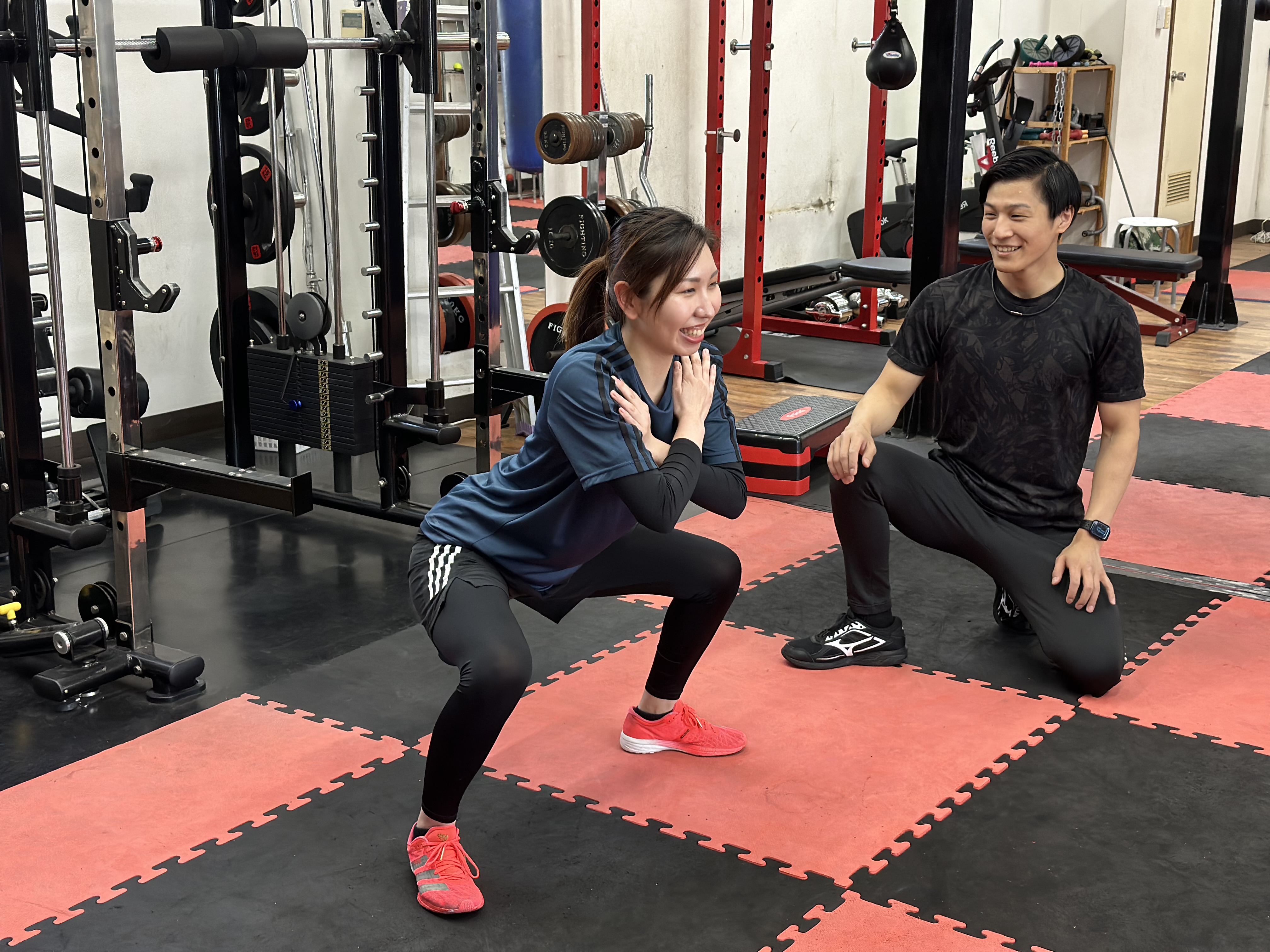 パーソナルトレーニングでスクワット指導を受ける様子